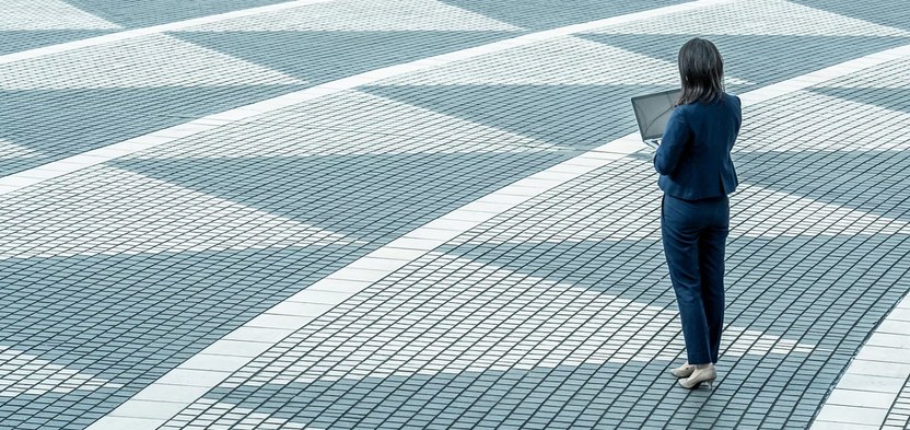 A colleague crossing the plaza with a laptop.